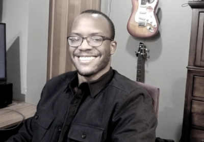 Mike Cornish sitting in a chair, smiling at the camera