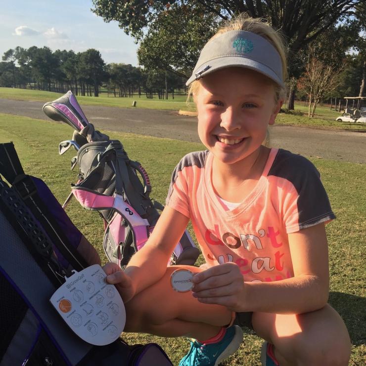 Junior Golfer showing off newly earned skill objective
