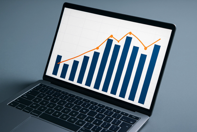 Laptop screen displaying a combination chart with blue bar columns and an orange trend line