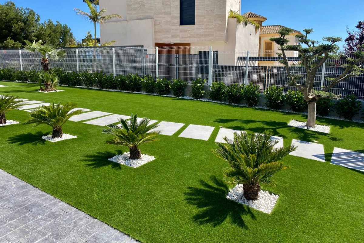 Luxe tuin met palm bomen en decoratieve stenen buiten een moderne villa met 3 slaapkamers in Finestrat.