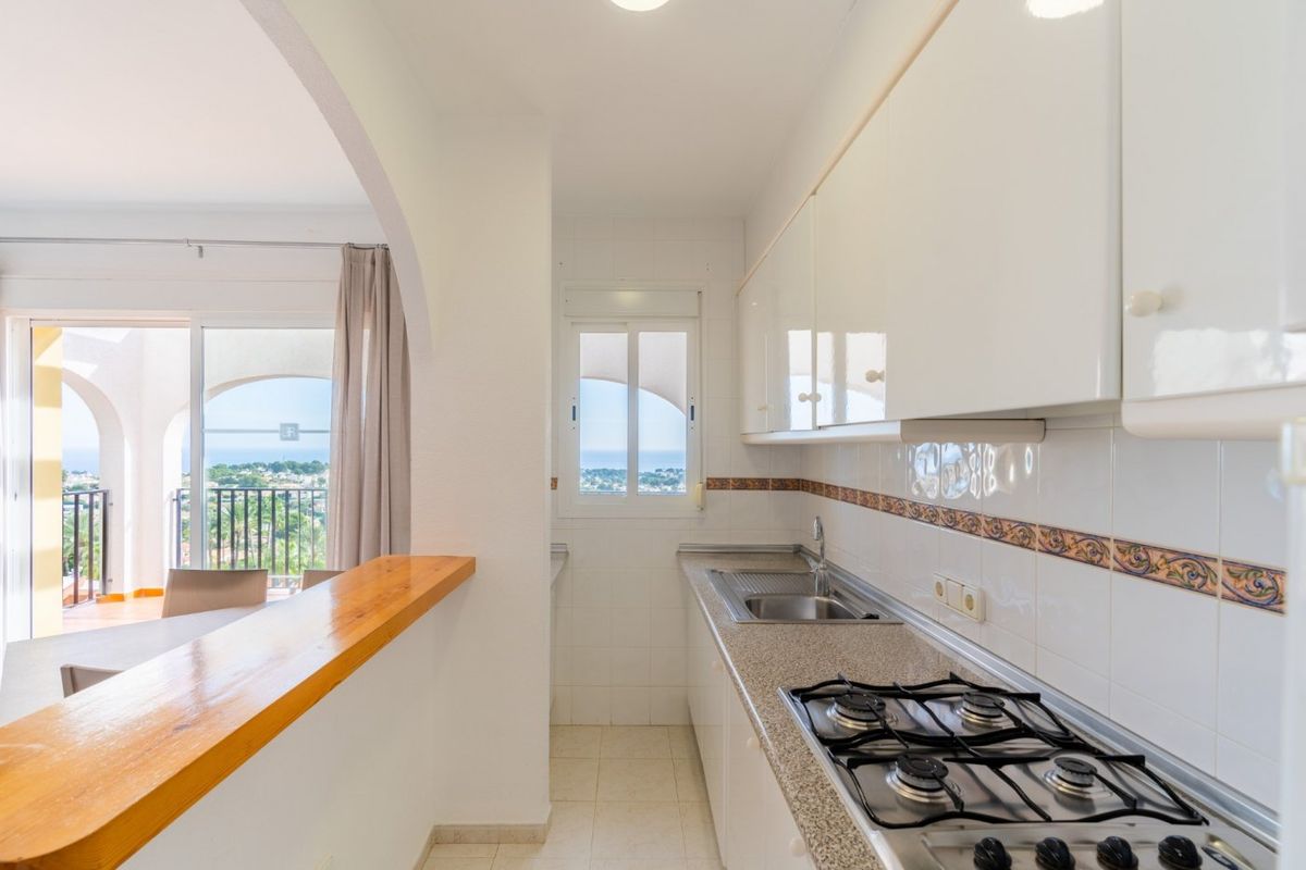Functionele keuken met witte kasten en zeezicht, in een 1-slaapkamer bungalow in Calpe.