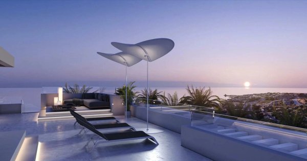 Ruime penthouse teras in Estepona met uitzicht, ligstoelen en modern ontwerp bij zonsondergang.