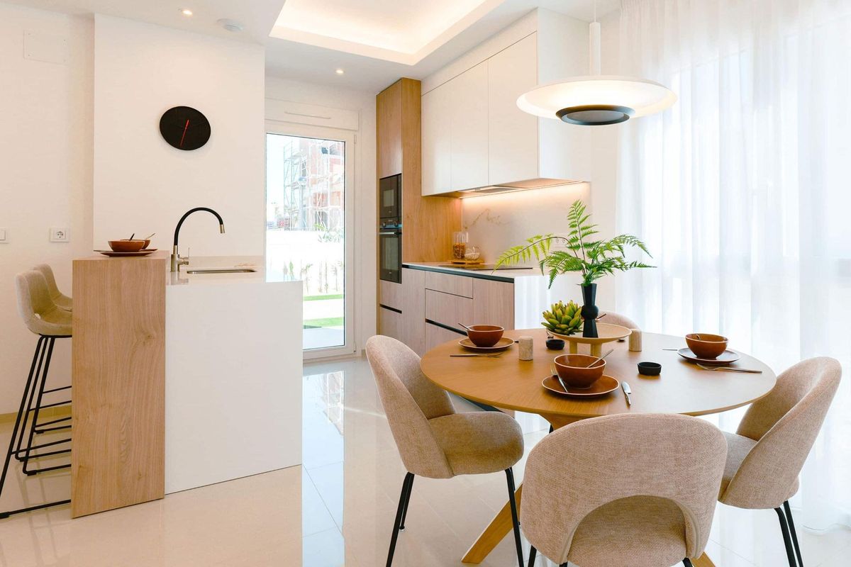 Moderne keuken met eetruimte in het Rojales appartement, met strakke apparaten en stijlvolle afwerkingen.