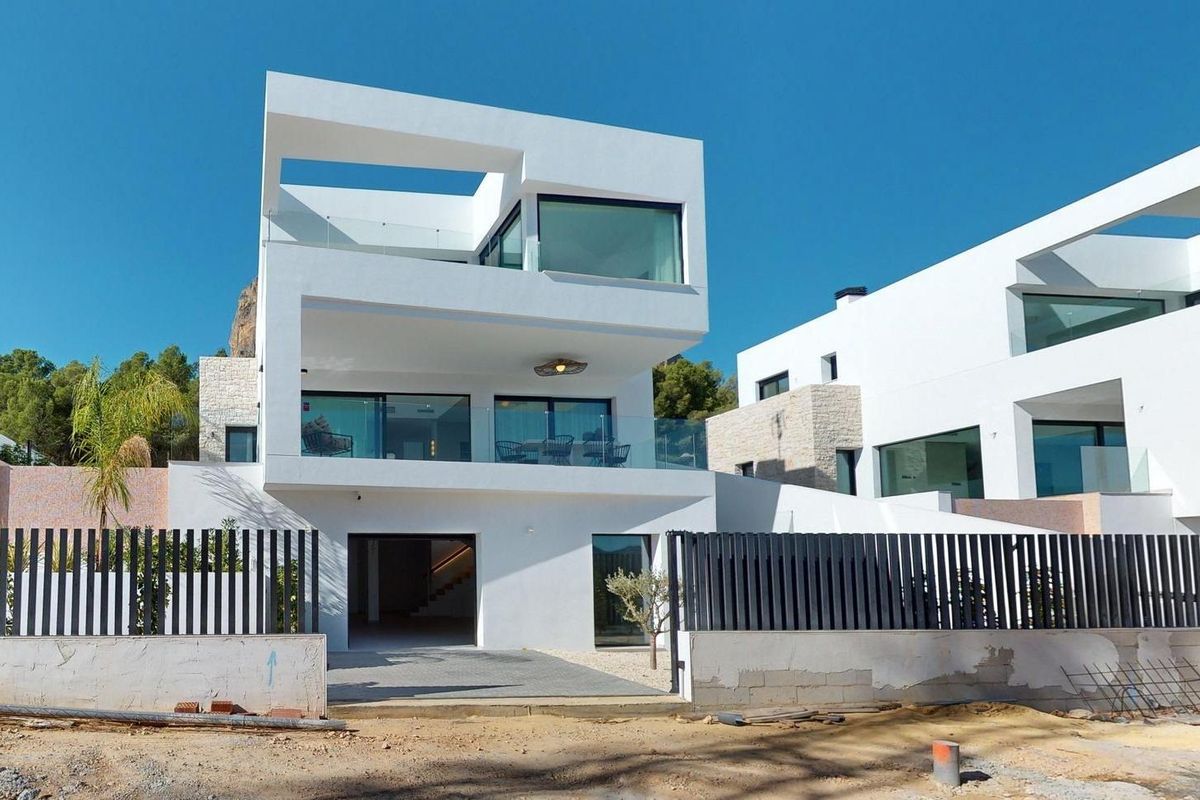 Moderne ingang van de villa in Polop, Costa Blanca, met glas- en steenelementen.