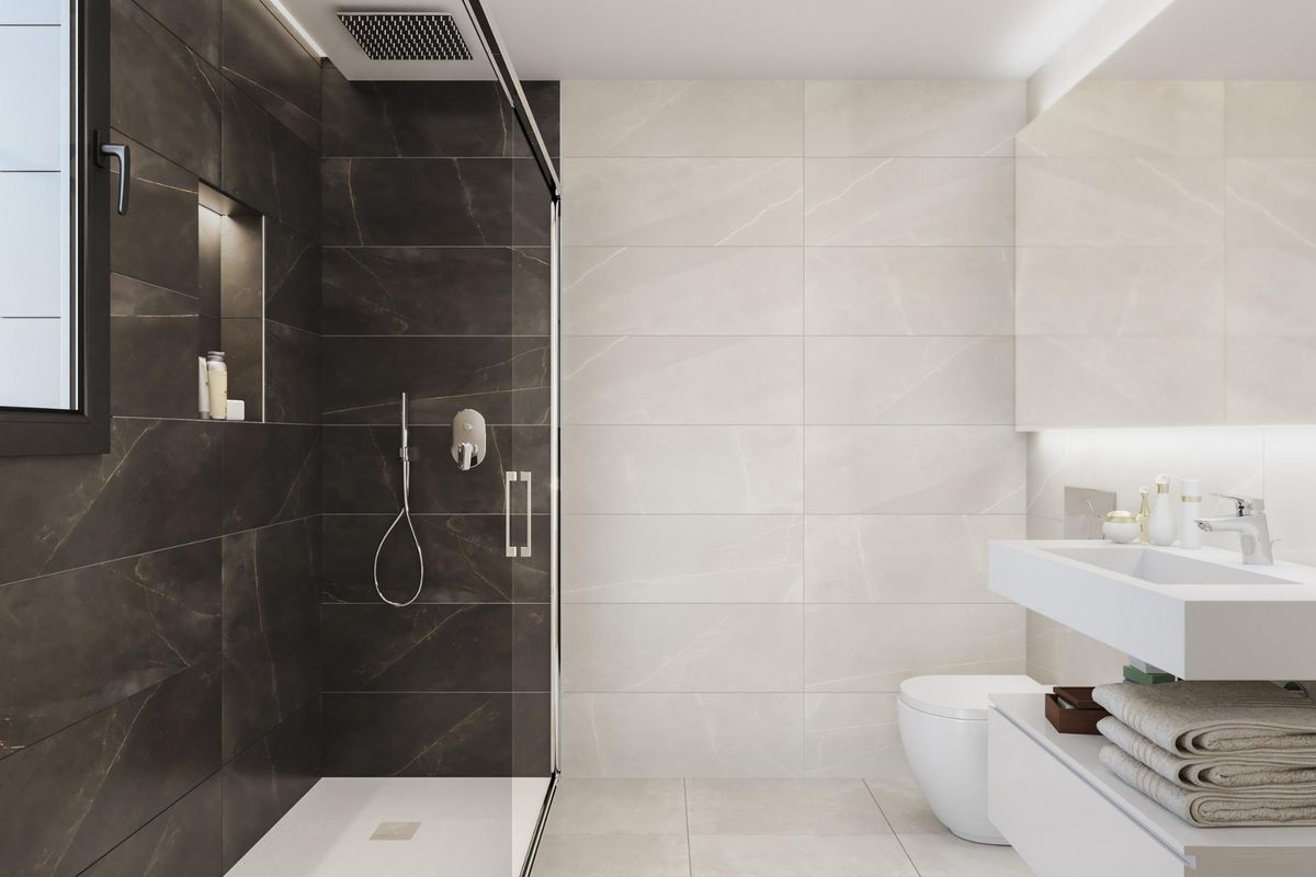 Elegante badkamer met donkere tegels in een appartement in Guardamar del Segura, voorzien van een ruime douche.