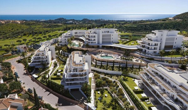 Luchtfoto van modern appartementencomplex in Mijas, Costa del Sol, met zwembaden en aangelegde tuinen.