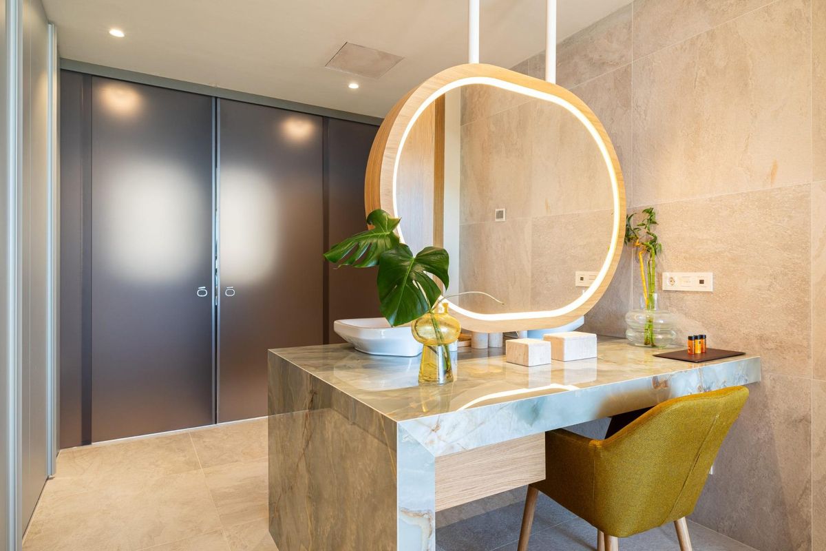 Stijlvolle badkamer met ronde spiegel en moderne afwerkingen in een penthouse in Fuengirola, Costa del Sol.