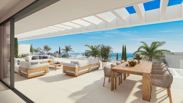 Ruimtelijk terras met een eettafel en loungestoelen, met uitzicht op de zee in Marbella, Costa del Sol.