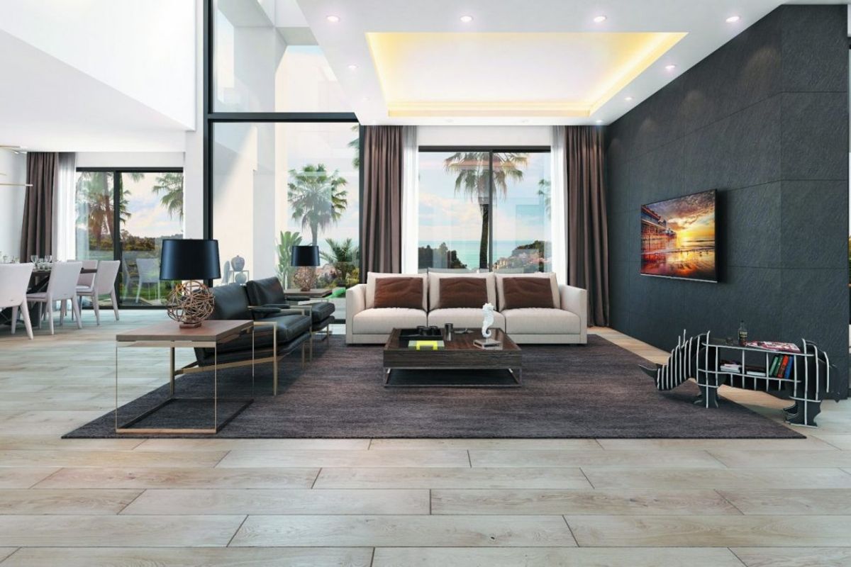 Ruime woonkamer in een eigentijdse villa in Málaga met grote ramen en elegante meubels.