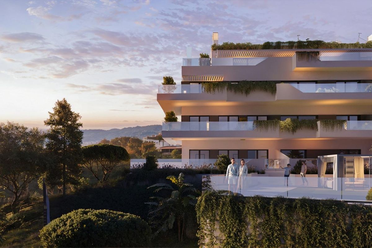 Buitenzijde van het stijlvolle moderne appartementencomplex in Mijas, Costa del Sol, omringd door groen.