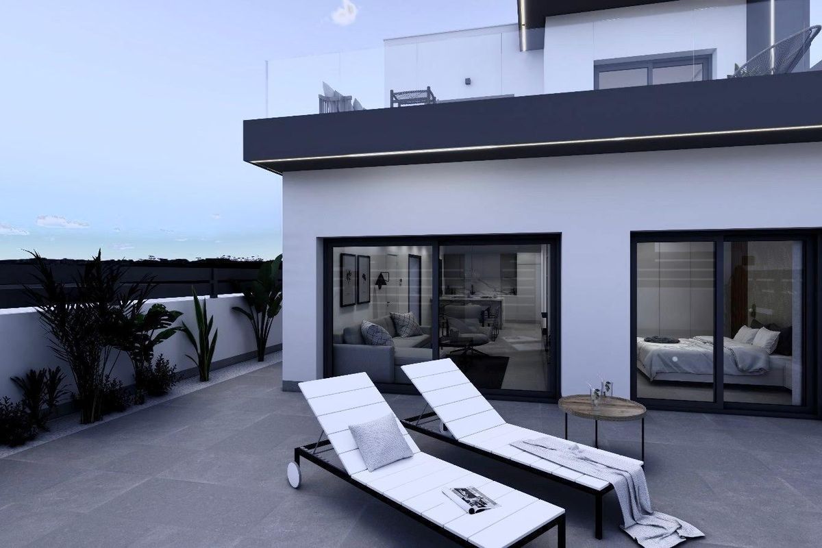 Avondzicht op een modern terras met ligstoelen bij een townhouse in Benijofar, Costa Blanca Zuid.