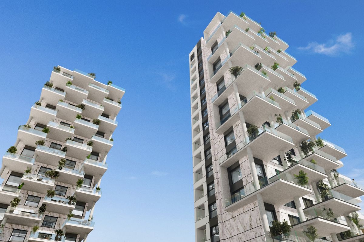 Nabijzicht van twee moderne torens in Calpe, Spanje, met weelderige balkons en eigentijds ontwerp.