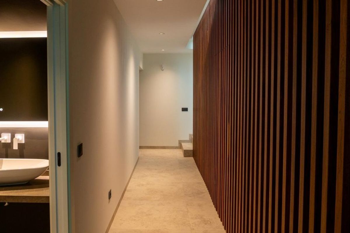 Hedendaagse gang die naar leefruimtes leidt, met warme houten accenten in een villa in Calpe.