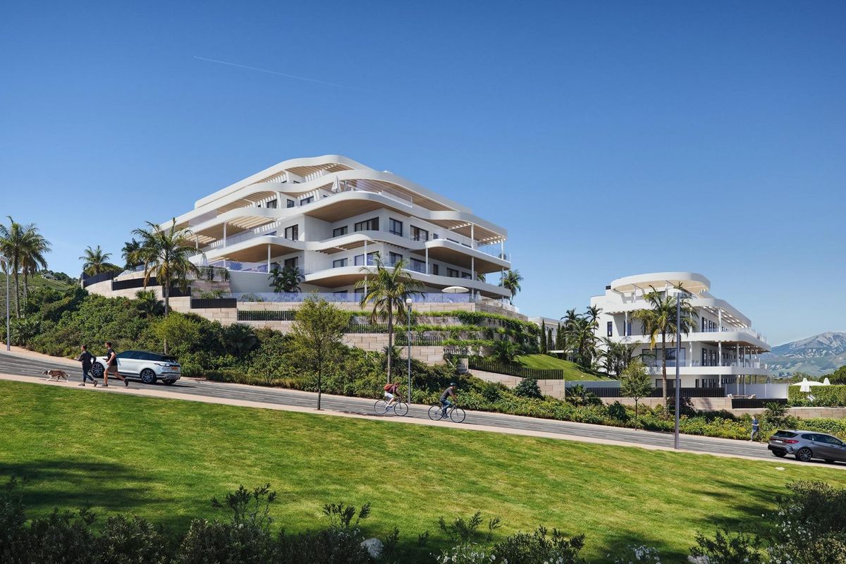 Stijlvol uitzicht op de buitenkant van een modern appartementcomplex omgeven door weelderig groen in Mijas, Costa del Sol.