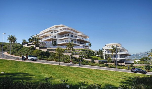 Modern appartementencomplex in Mijas met weelderig groen en bergen op de achtergrond, Costa del Sol.