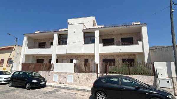 Buitenkant van een modern appartement op de begane grond in Hondón de las Nieves met witte gevel en parkeerplaatsen.