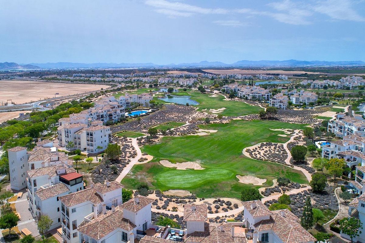 Luchtfoto van een woongebied in Sucina, met golfbanen en het omliggende landschap.