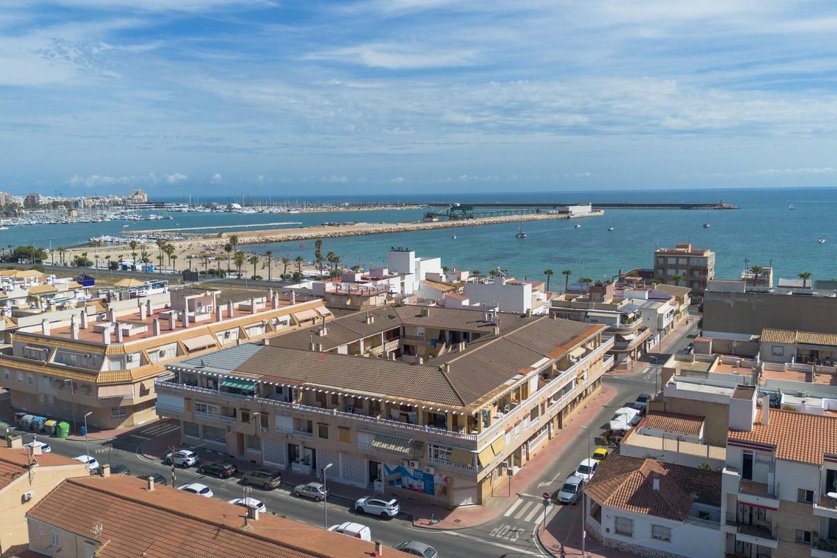Luchtfoto van Torrevieja die het kustgebied en de haven benadrukt, dicht bij het appartement.