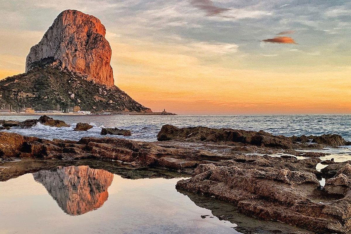 Incredible zonsondergang uitzicht op de rotsformatie van Calpe die zich op de zee weerspiegelt, een perfecte setting voor avondontspanning.