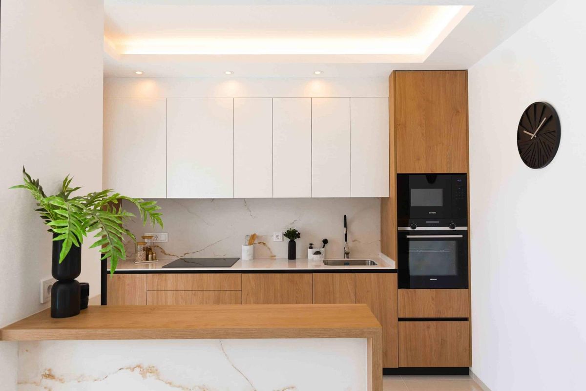 Stijlvolle keuken met houten kasten en moderne apparatuur in een bungalow in Rojales.