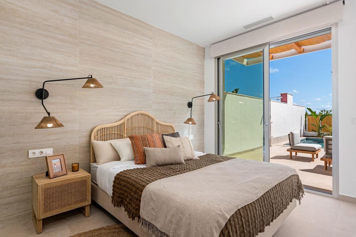 Elegante slaapkamer in villa in Benijofar met moderne decor en directe toegang tot het buitenzwembad.