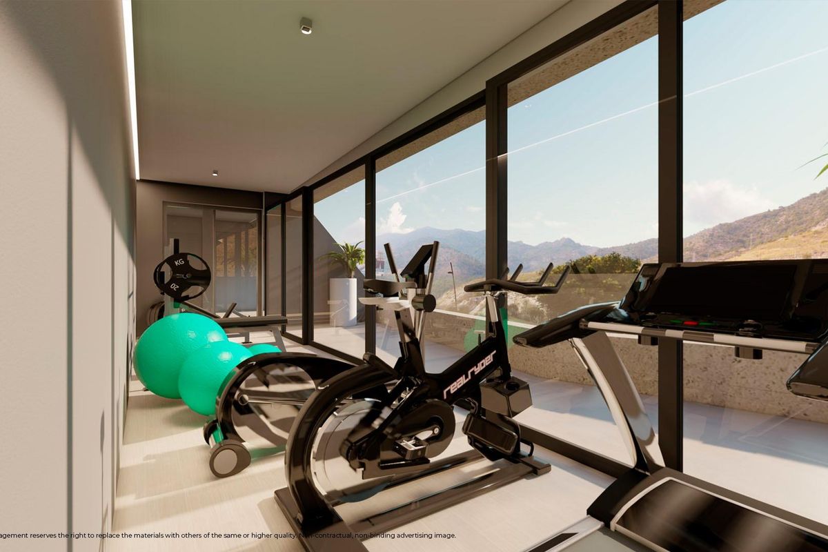 Thuis sportschool met fitnessapparatuur en uitzicht op de bergen in een penthouse in Benalmádena.