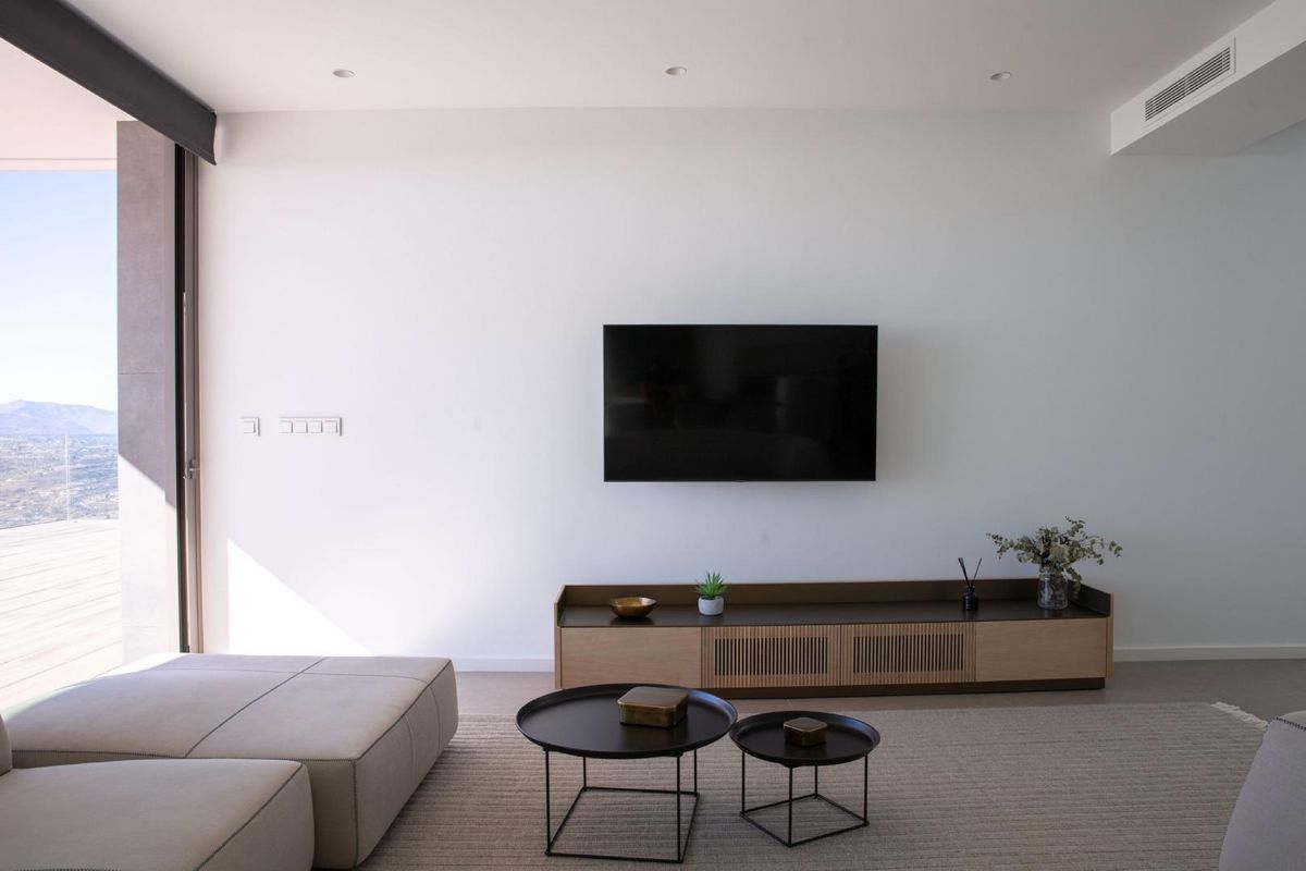 Cozy living room within the villa featuring a TV and stylish furnishings, overlooking the landscape.