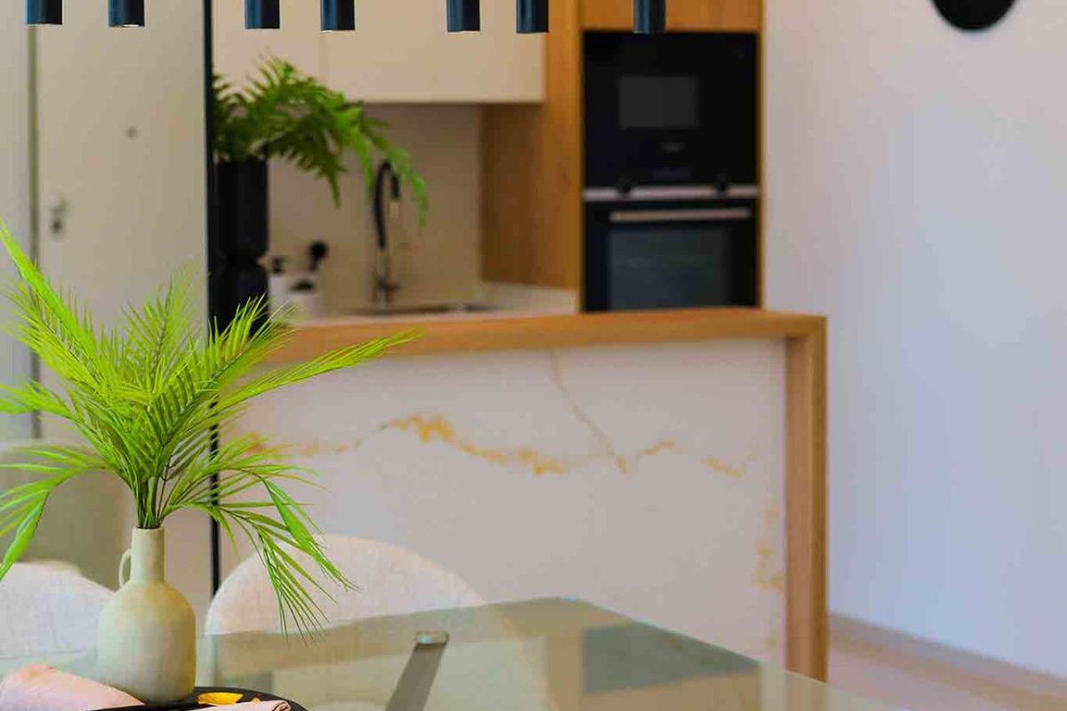 Eetkamer met elegante verlichting en uitzicht op de keuken in een woning in Rojales.