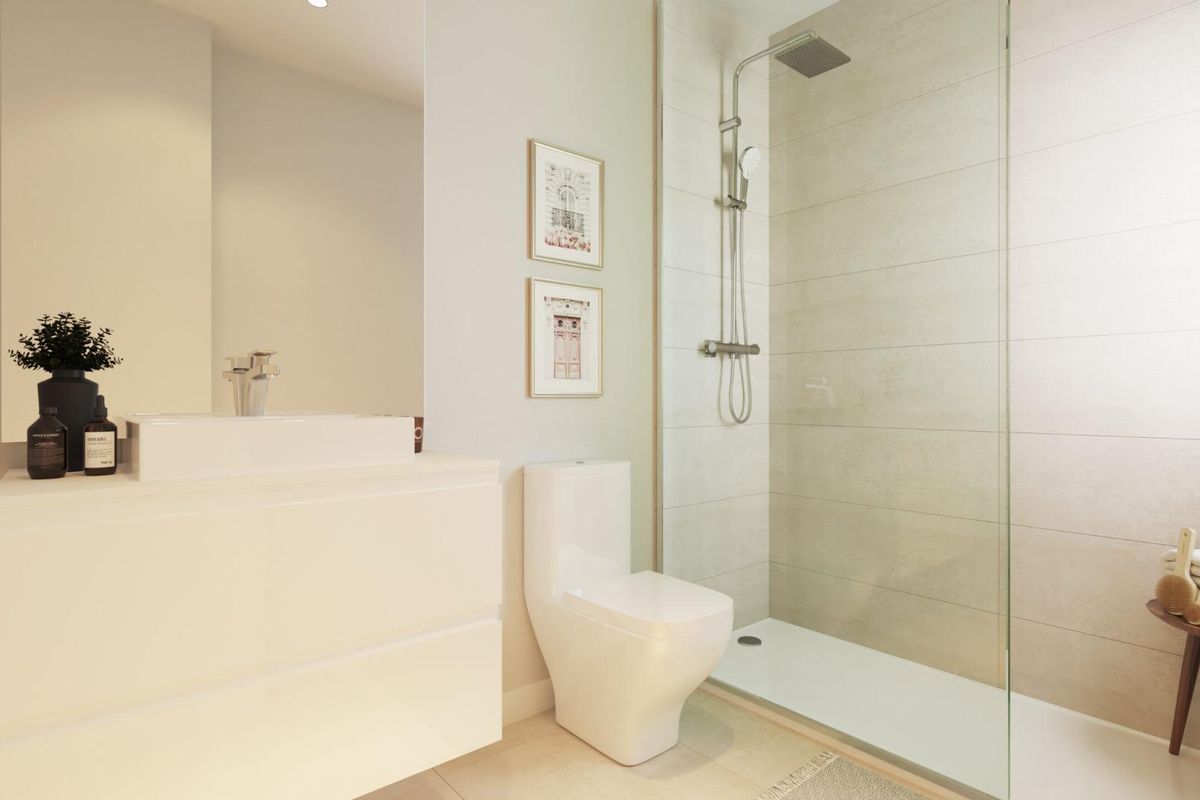 Elegante badkamer in een gelijkvloers appartement in Estepona, met een inloopdouche en moderne armaturen.