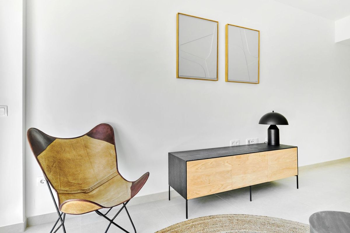 Stijlvolle woonkamer in een 2-slaapkamer bungalow in Torrevieja, met moderne kunst en een gezellige stoel.