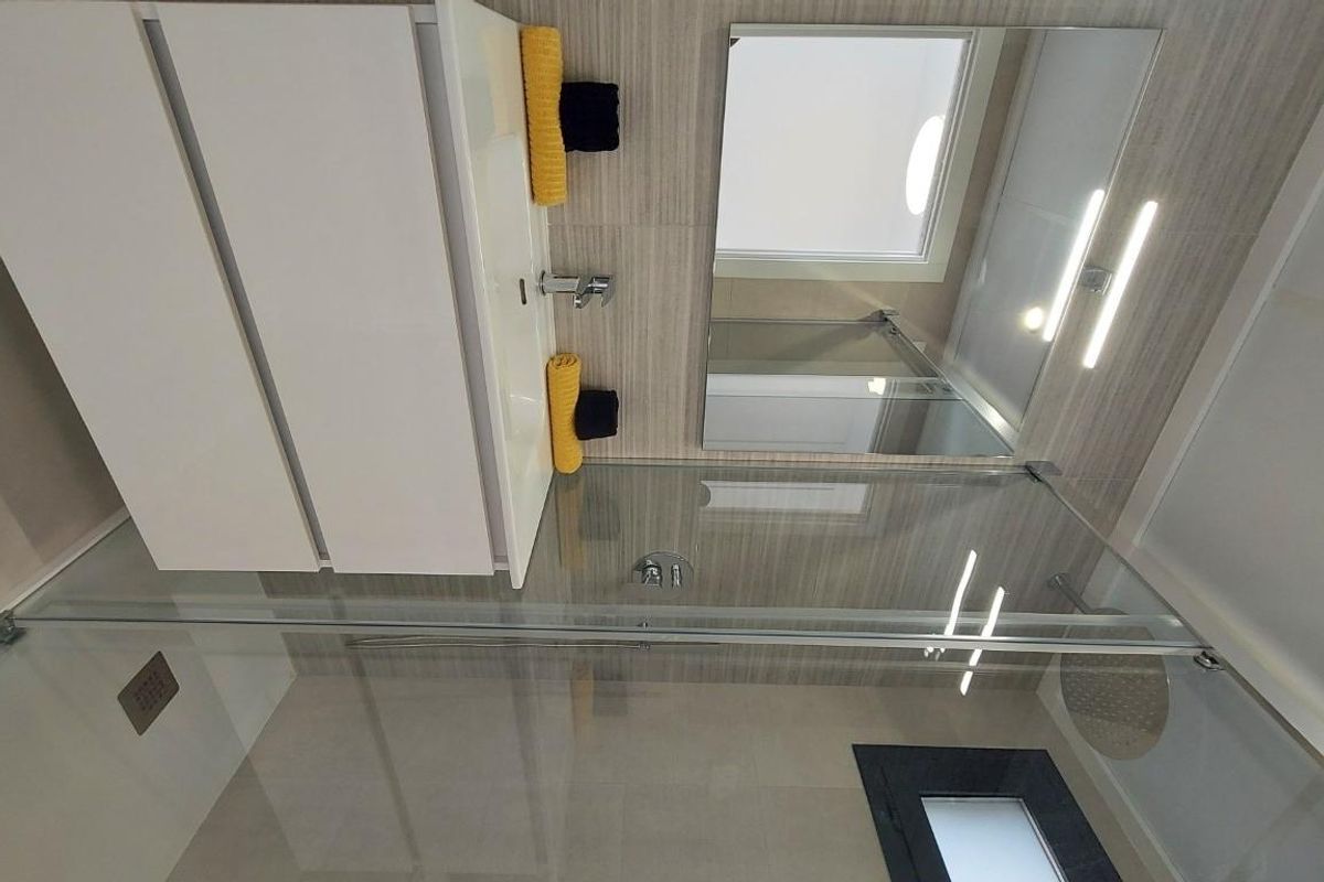 Stijlvolle douche in de moderne badkamer van het penthouse in San Miguel de Salinas, met glas en tegels.