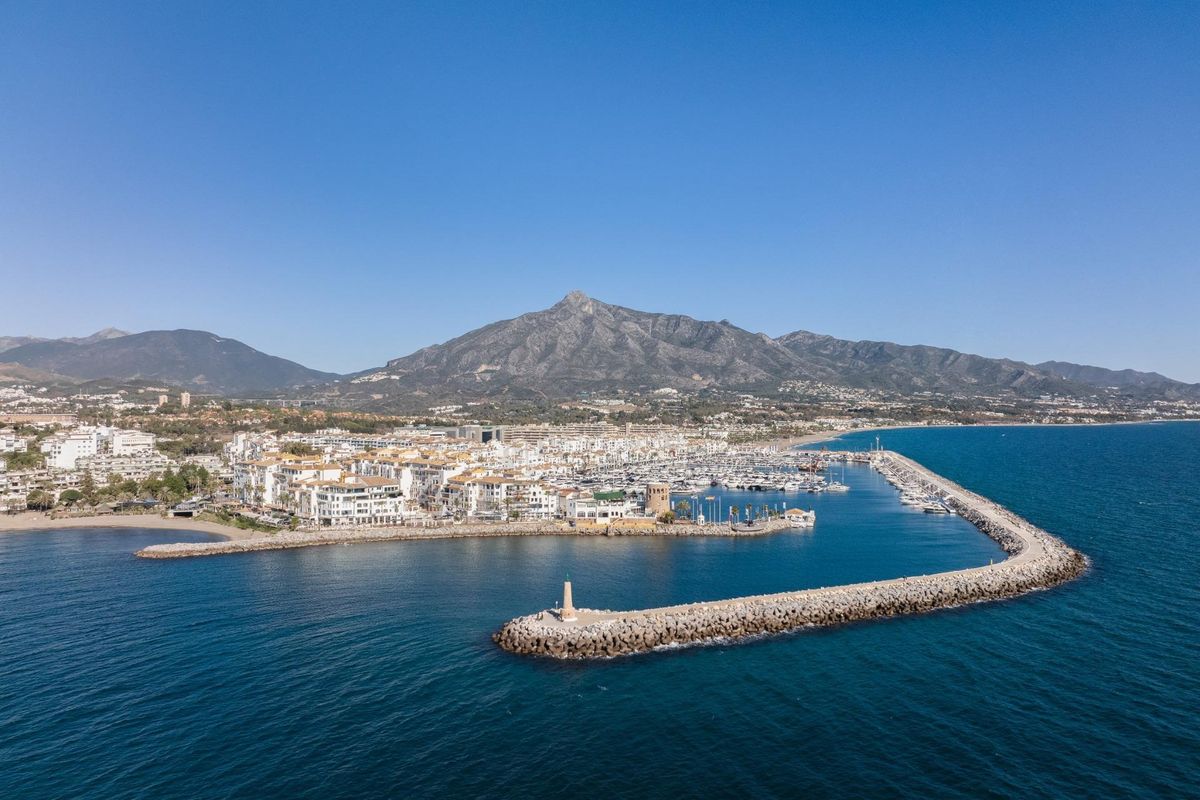 Luchtfoto van Marbella, Costa del Sol, met kustarchitectuur en omliggende bergen.