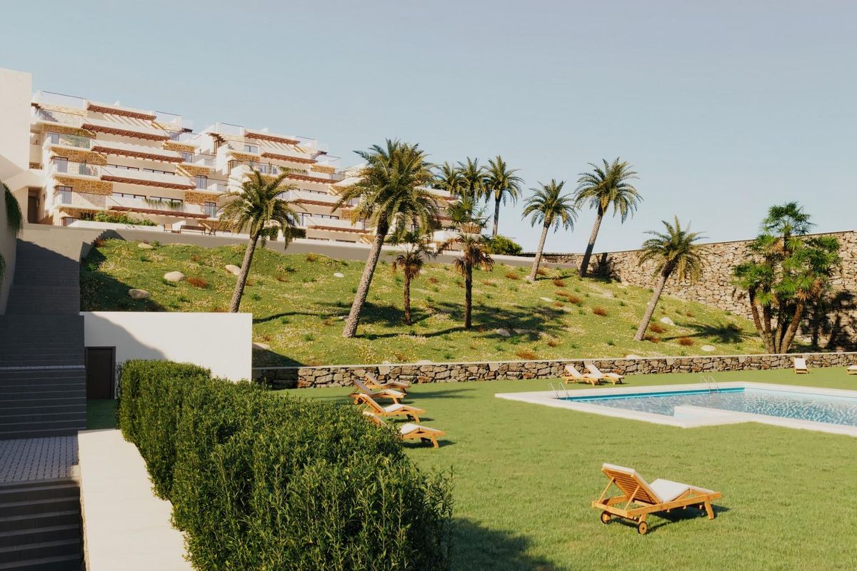 Goed onderhouden tuin van het penthousecomplex, met een zwembad, palmbomen en ligstoelen.