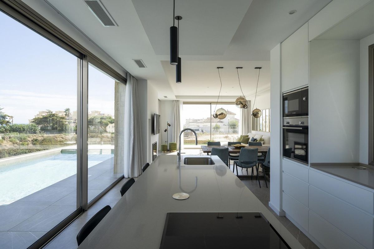 Open keuken met uitzicht op het zwembad en moderne meubels in een 4-slaapkamer villa in Mijas, Costa del Sol.