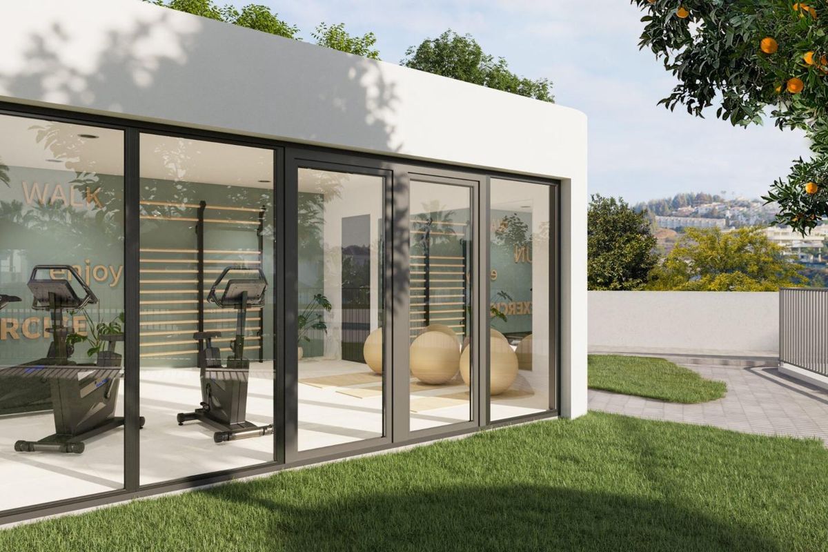 Buitenzicht op het fitnesscentrum met grote ramen en groene omgeving in Mijas, Costa del Sol.