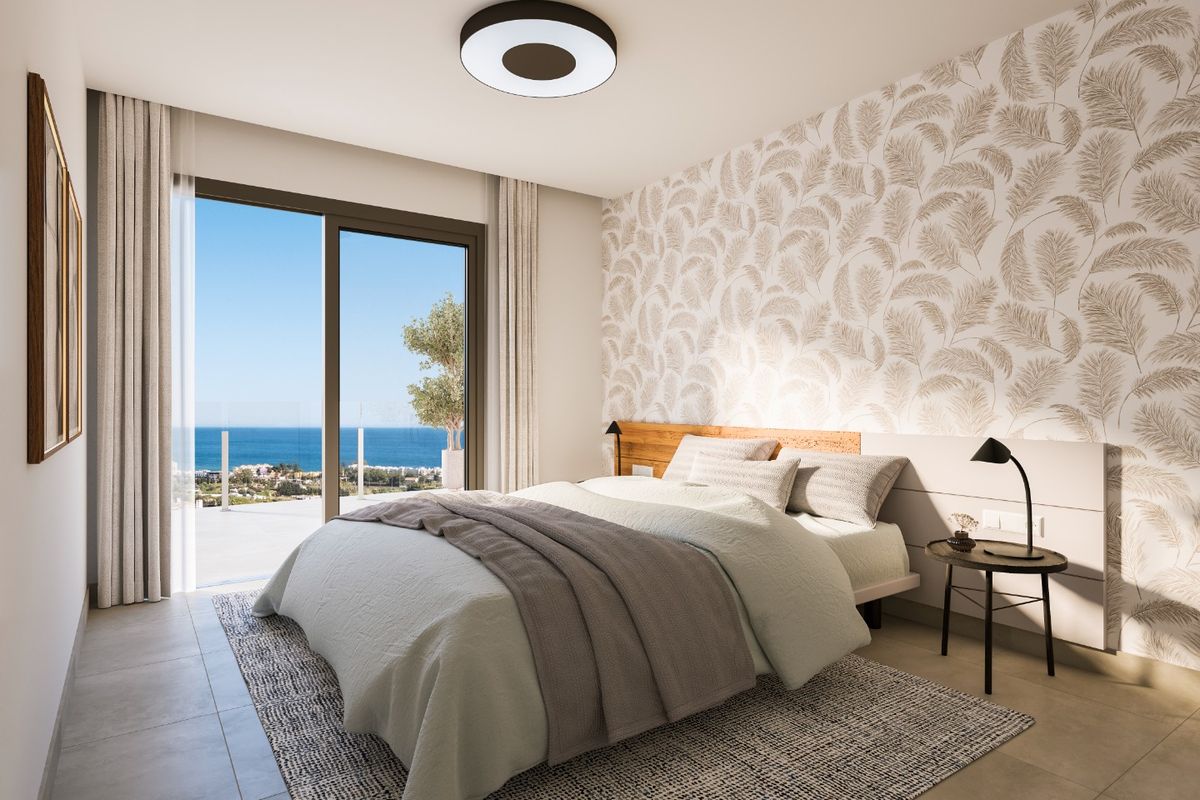 Stijlvolle slaapkamer met grote ramen en prachtig uitzicht op de oceaan vanuit Estepona.