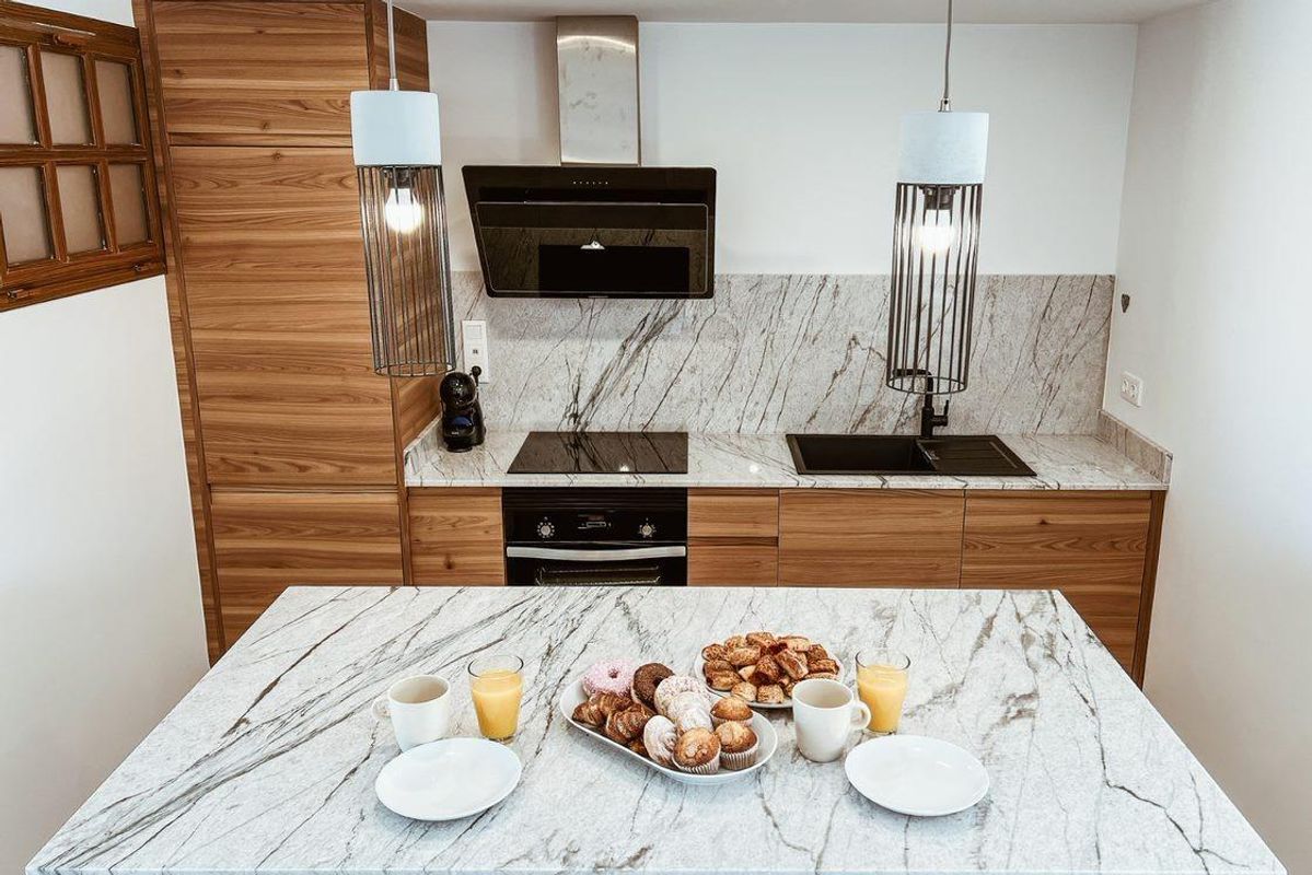 Moderne keuken met houten kasten en ontbijtitems in het appartement in Cuevas Del Almanzora, Costa de Almeria.