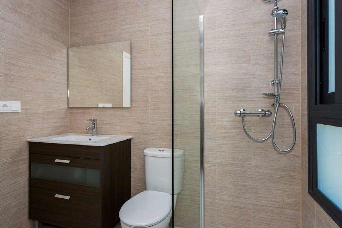 Strakke badkamer in een bungalow in Daya Nueva, compleet met moderne douche en stijlvolle wastafels voor gemak.