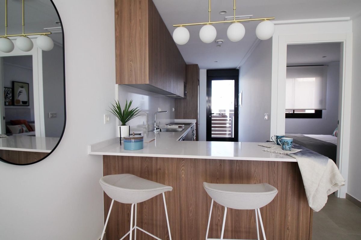 Elegante keuken met een kookeiland en moderne afwerking in de rijtjeswoning in Pilar de La Horadada.