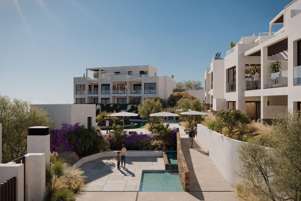 Buitenzicht op het appartementencomplex in Mojacar met aangelegde tuinen en een zonnig zwembad.