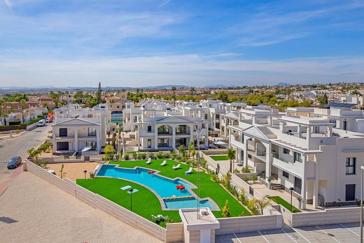 Breed zicht op het appartementencomplex in Rojales, met meerdere pools en tuinen in het oog.