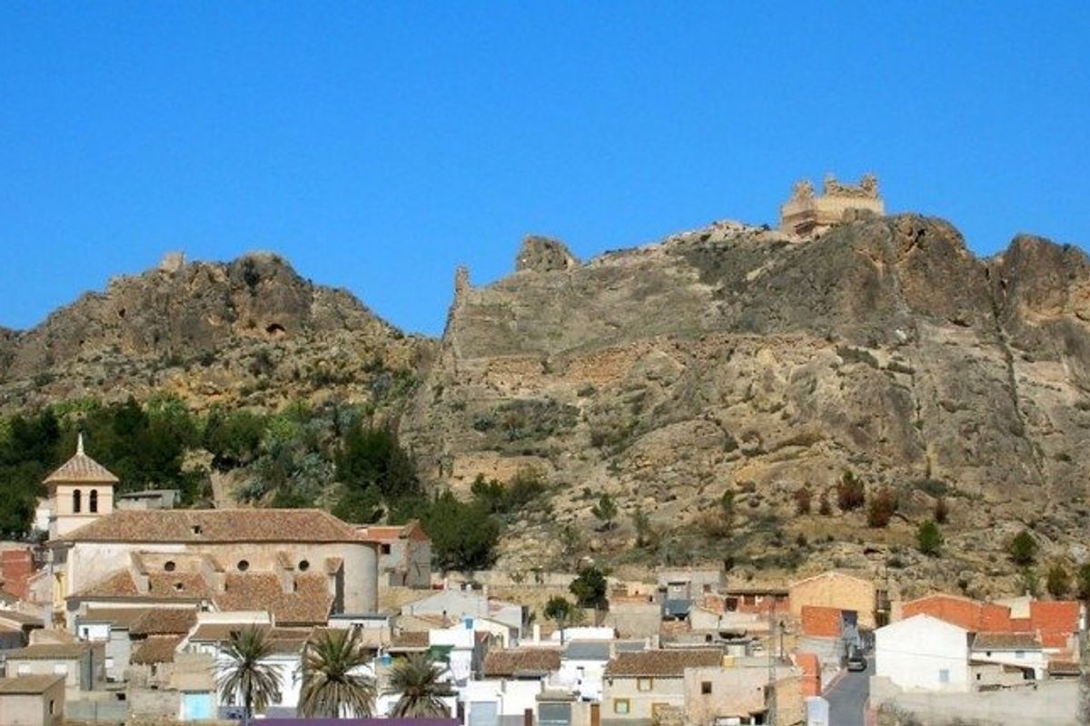 Historische kasteelruïnes met uitzicht op Calasparra, gelegen op een rotsachtige heuvel met het omliggende dorp.