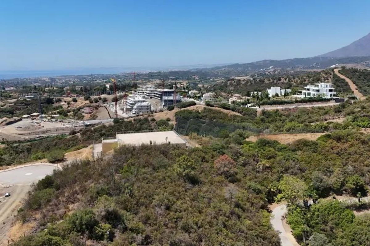 Bouwvoortgang met betonnen pilaren en machines in Estepona, Costa del Sol, voor nieuwe appartementen.