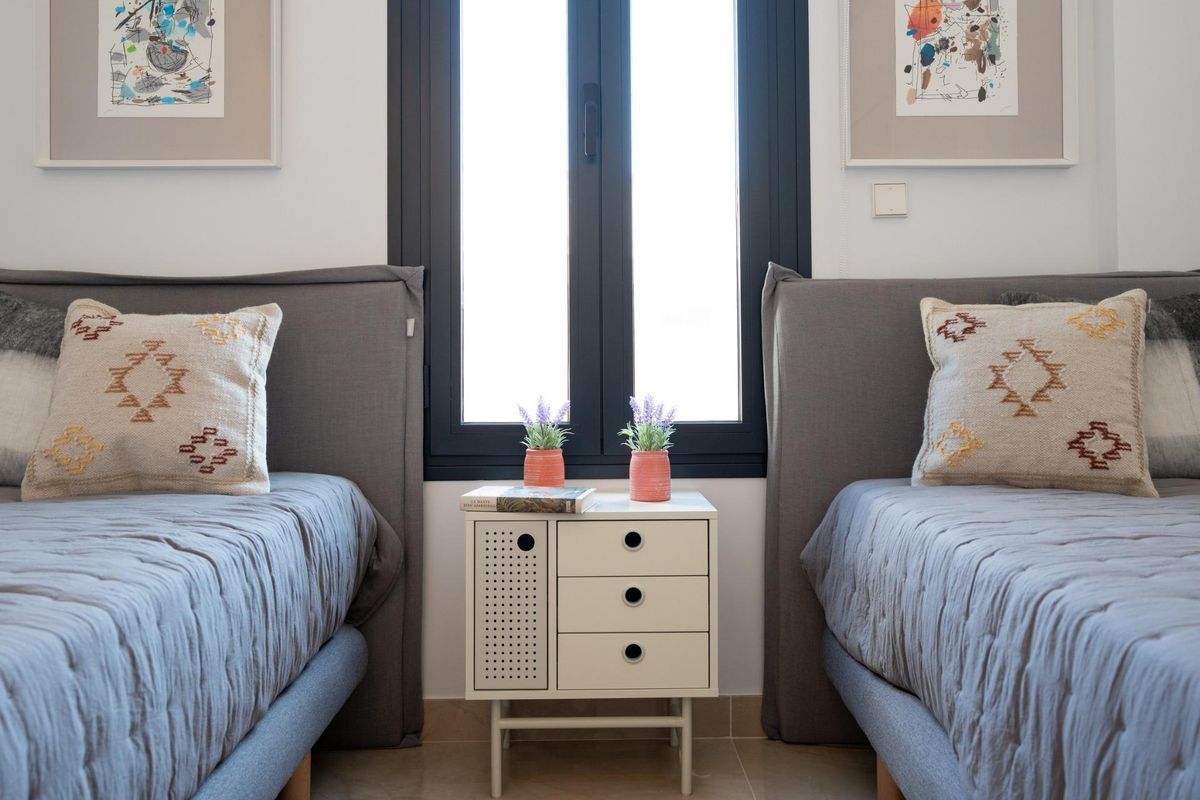 Twee eenpersoonsbedden met decoratieve kussens in een gezellige slaapkamer van een town house, Gran Alacant, Spanje.