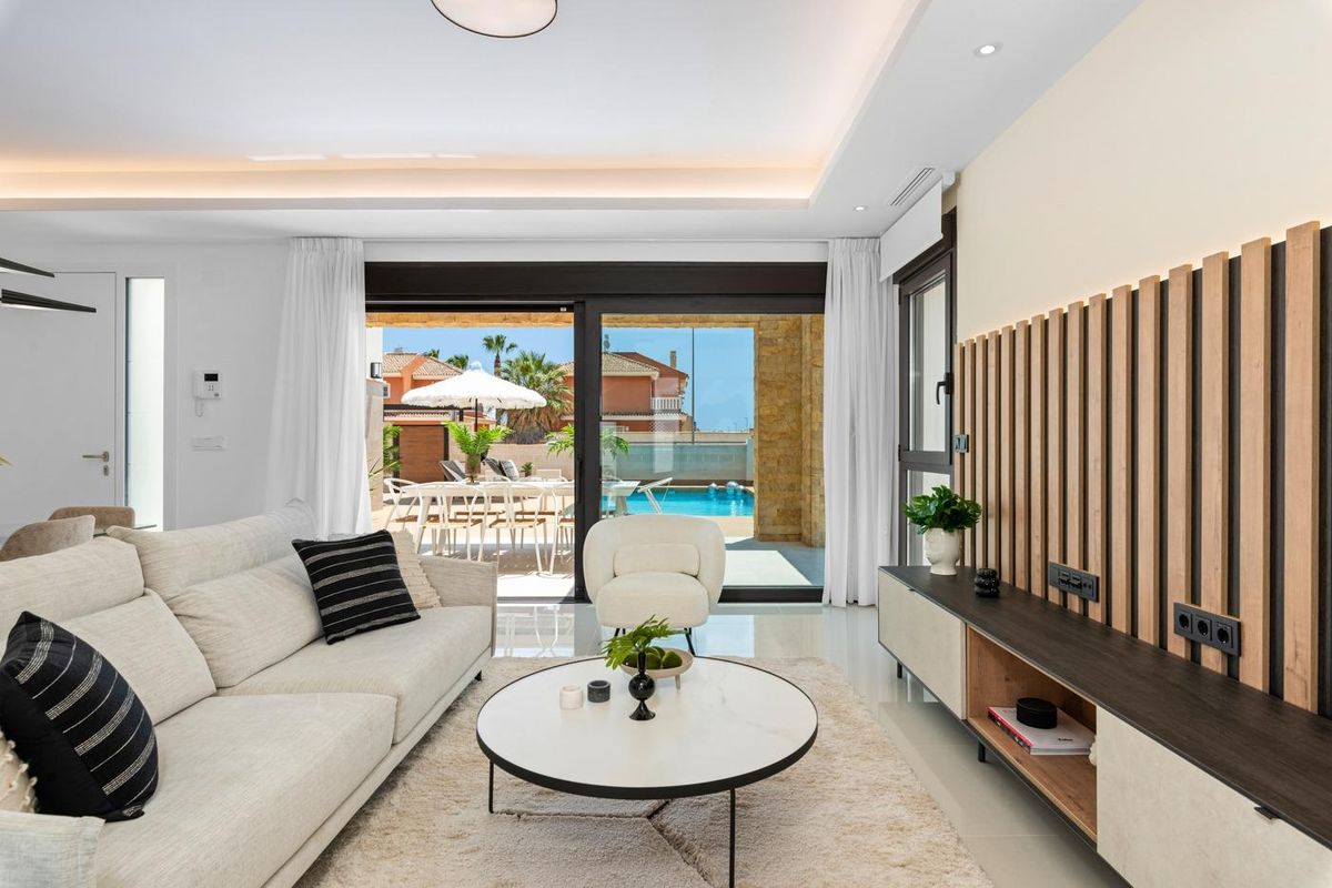 Woonkamer met moderne kenmerken en uitzicht op het zwembad in een villa in Ciudad Quesada, Spanje.