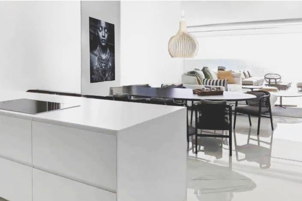 Bright open plan kitchen and living area in a Relleu apartment, with modern furniture and sleek white surfaces.