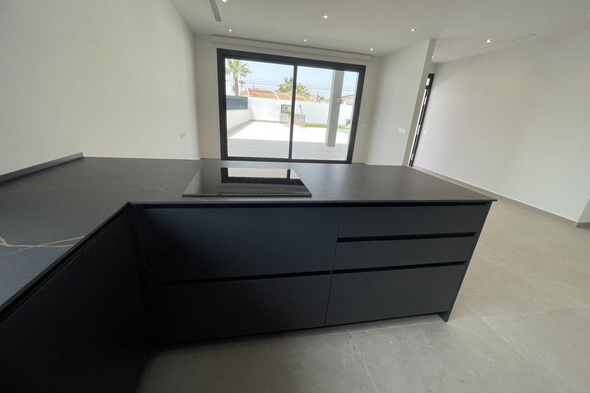 Uitzicht op het moderne kookeiland, leidend naar de ruime woonkamer in een 3-slaapkamer villa, Rojales, Spanje.