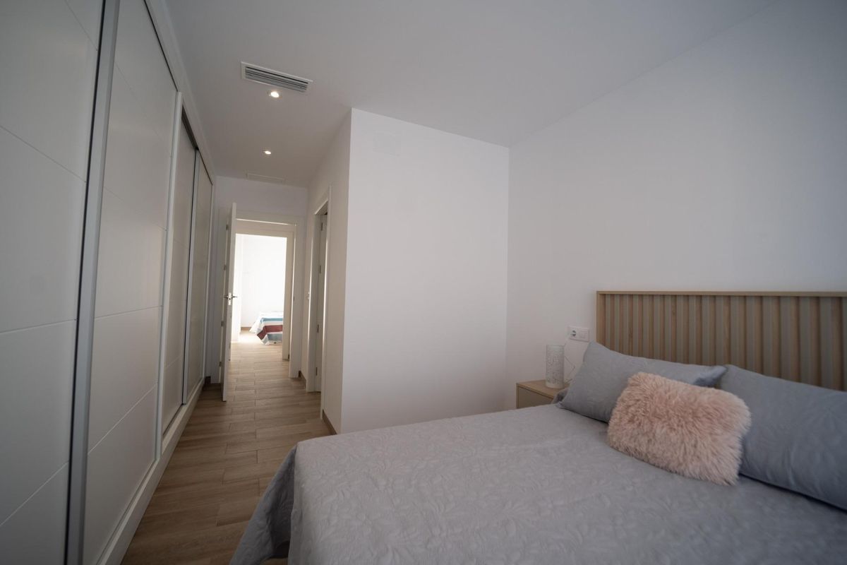 View through a bedroom doorway, showcasing bed and large wardrobe in this 3-bed Costa Calida townhouse.
