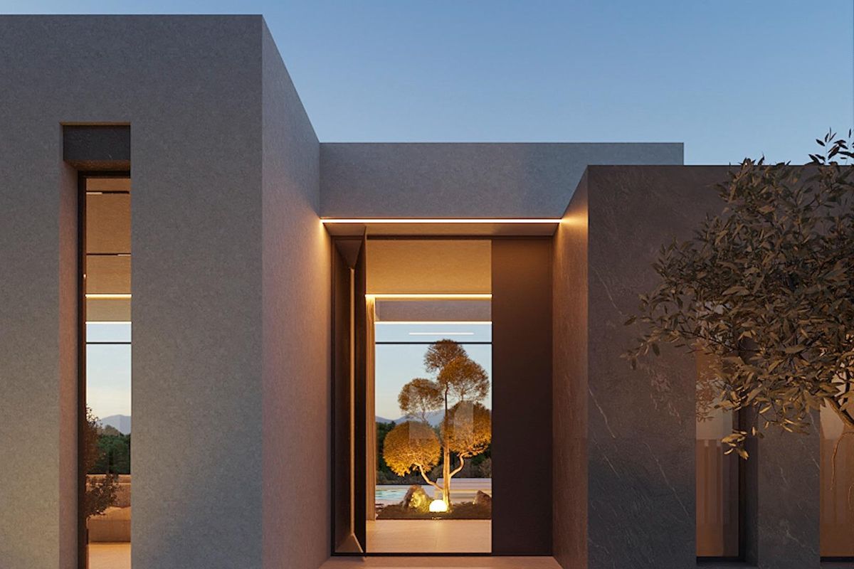 Ingang van de villa toont moderne architectuur in Calpe, omringd door groen en warme verlichting.