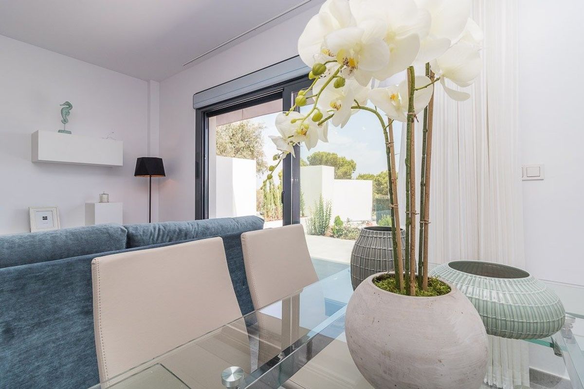 Elegante eetkamer met bloemen en uitzicht op de tuin in een appartement in Torrevieja.